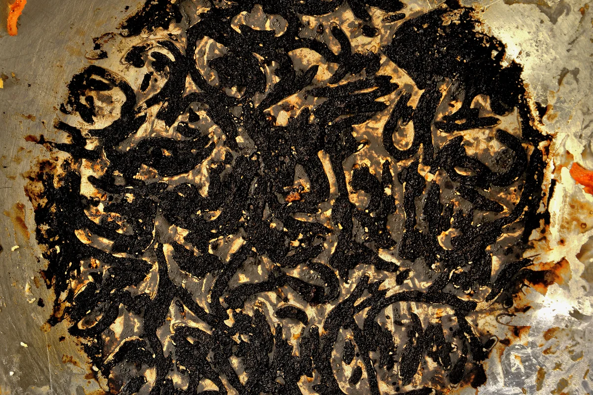 Close view of burnt-on food residue in a pan
