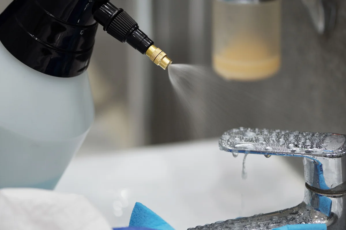 Bathroom faucet being carefully cleaned